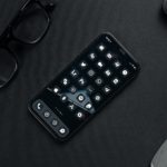 black remote control beside black framed eyeglasses